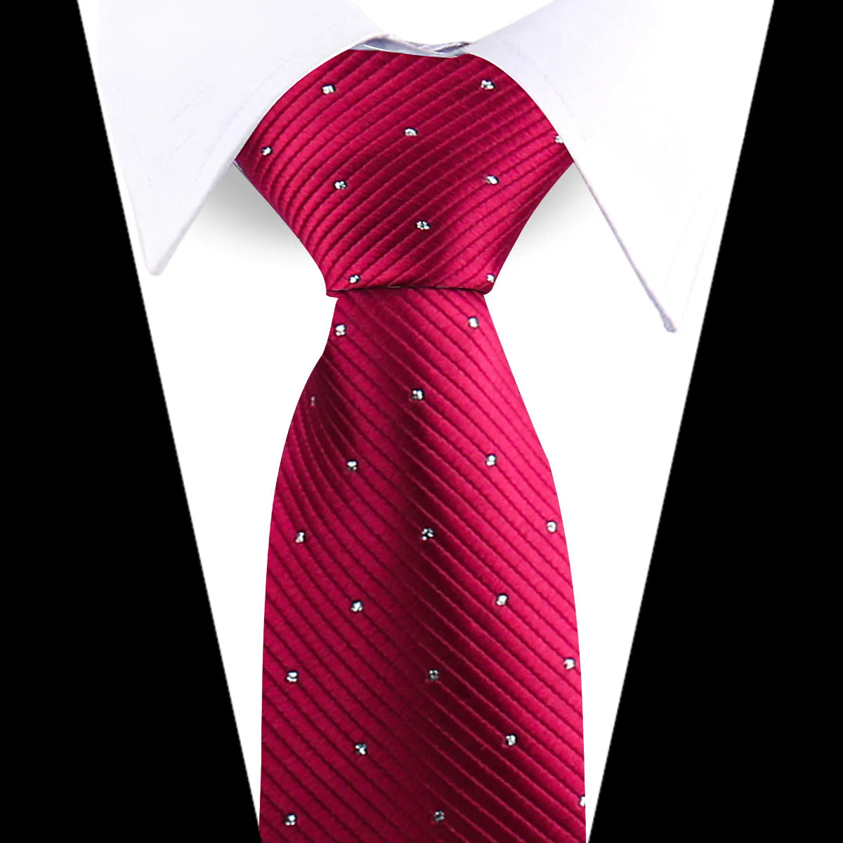 A close-up of a red patterned silk necktie worn under a white dress shirt.
