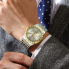A close-up of a men's luminous quartz wristwatch with a silver and gold bezel worn on a wrist, next to a suit jacket.