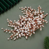 A delicate bridal headpiece made of rose gold wire adorned with pearl and clear rhinestone embellishments.