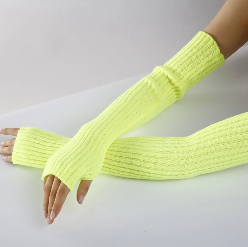 A hand wearing a bright neon yellow knitted fingerless glove on the wrist and forearm.