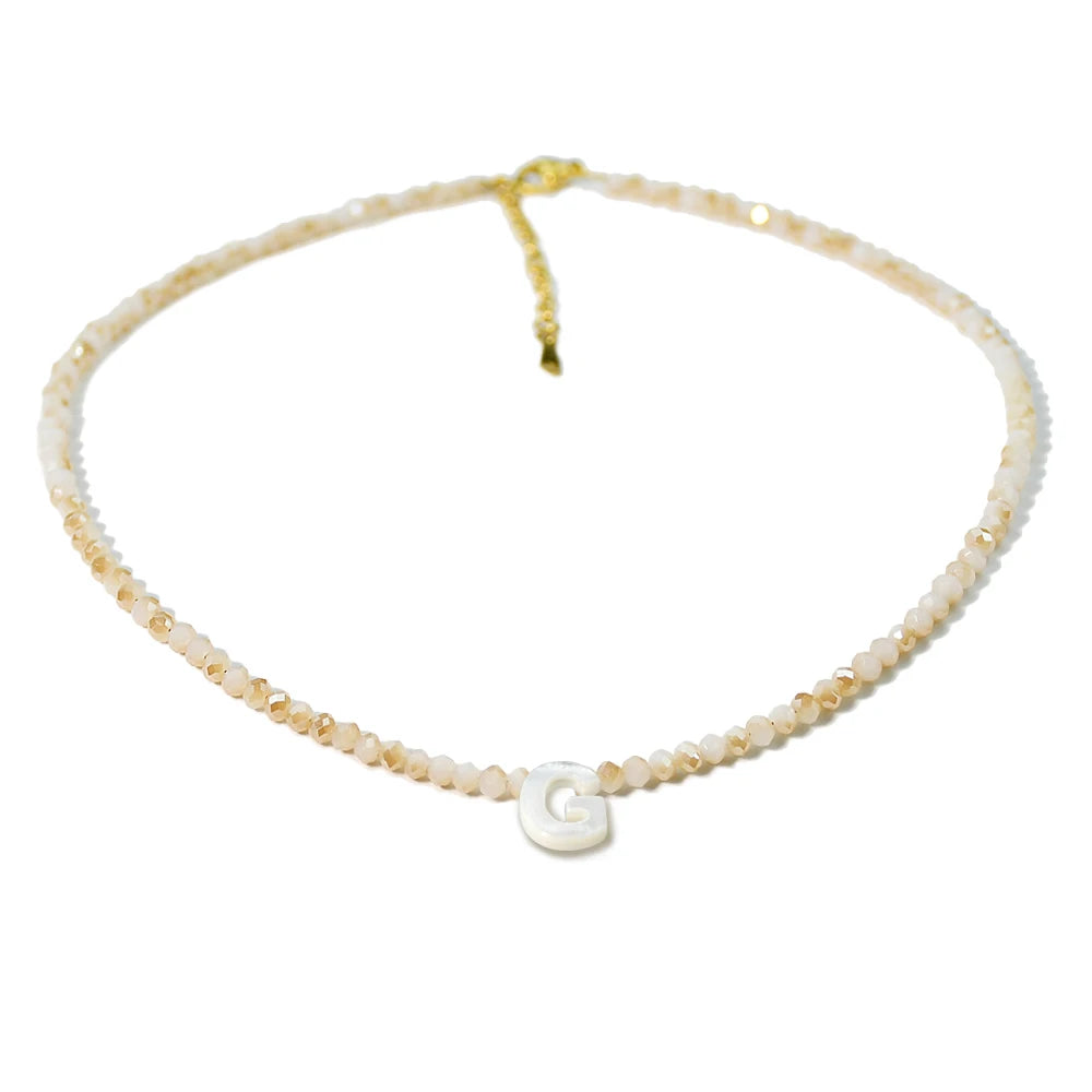 A delicate necklace made of mother of pearl beads with crystal accents and a gold-colored chain.