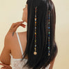 A woman shows off long black hair adorned with a bohemian sun moon tassel headdress