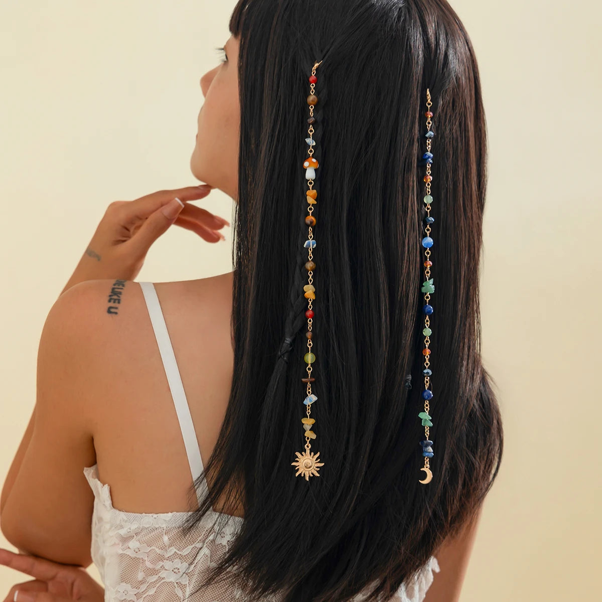 A woman shows off long black hair adorned with a bohemian sun moon tassel headdress