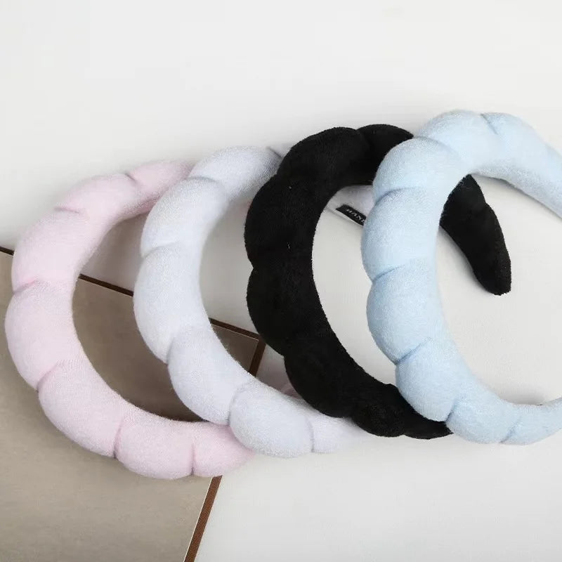 Un pack de trois bandeaux de spa et bracelets élégants en rose, blanc et noir.