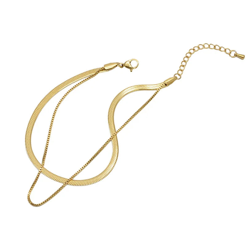 A gold double snake anklet with a chain and clasp is displayed against a white background.