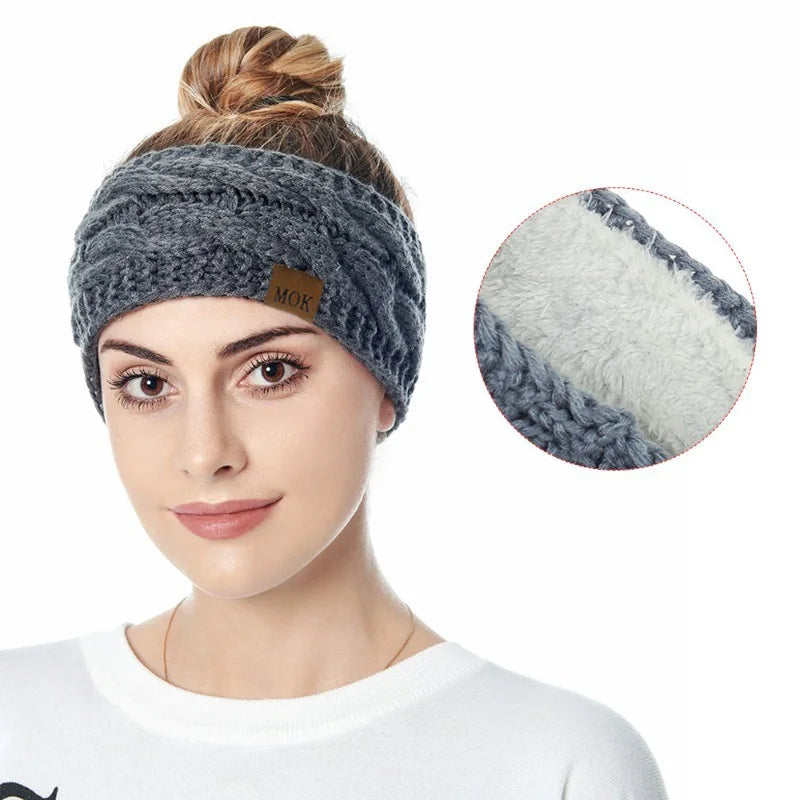 A woman wearing a gray knitted plush winter ear warmer headband with a white and gray striped detail.