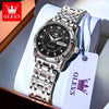 A stainless steel watch with a black face and silver bezel is displayed in a box with a white tag.