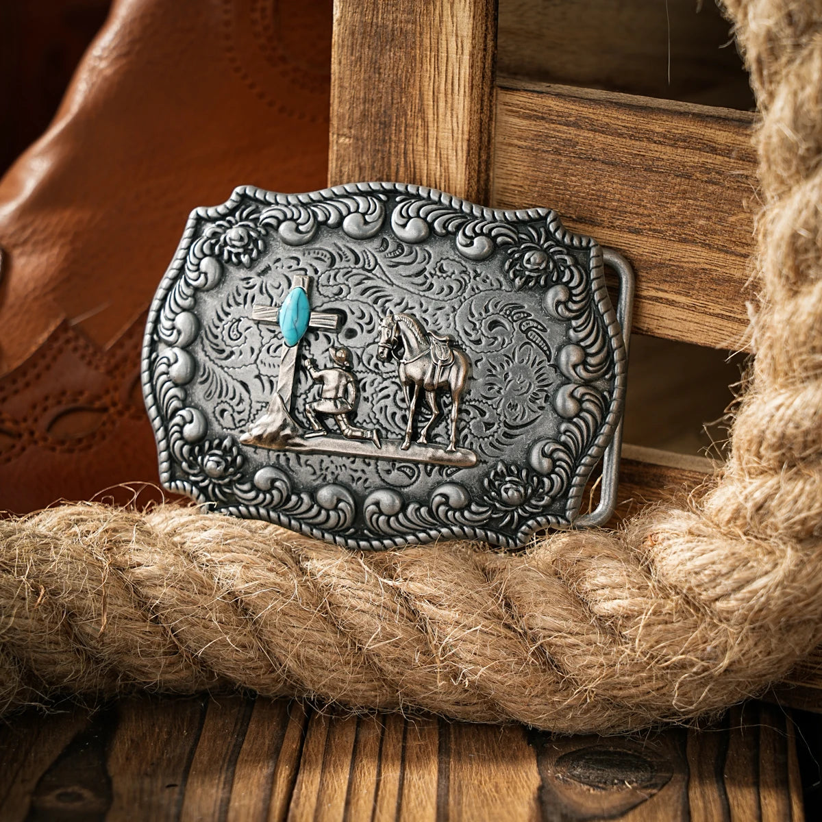 Boucle de ceinture en métal argenté représentant un cavalier et un cheval, posée sur une surface en bois rustique.