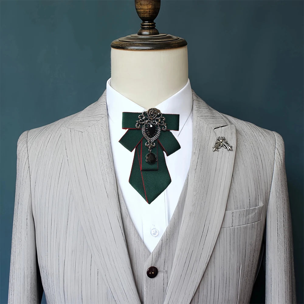 A light gray tailored suit jacket displayed on a mannequin with a dark green tie featuring diamond embellishments.
