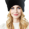 A woman models a black crocheted cat ears beanie hat with long blonde hair and a white sweater.