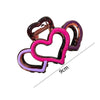 A set of three heart-shaped hair claws in shades of purple, pink, and dark purple.