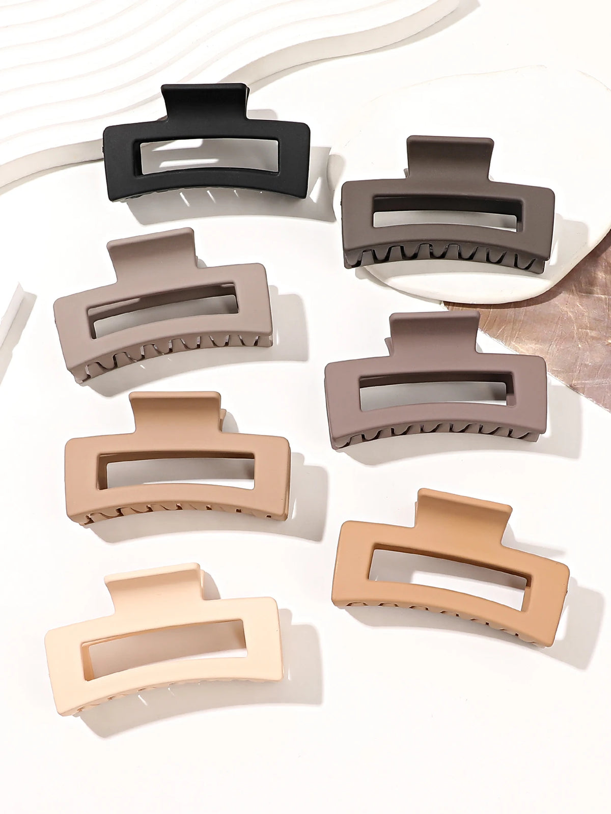 A set of seven square hair claw clips in various matte beige and gray tones displayed on a white background.