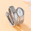 A silver quartz watch with a snake design on the band is shown on a light background.