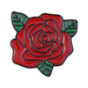 A red enamel flower brooch with green leaves.