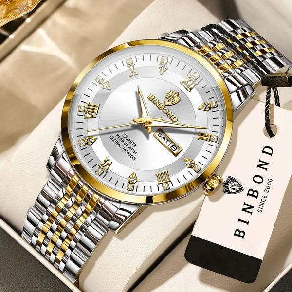 A gold and silver quartz wristwatch with a metal bracelet is displayed on a light-colored box.