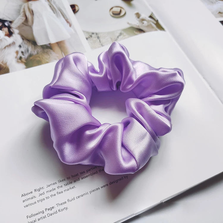 Un lazo de cabello de seda morado se muestra en una página blanca junto a texto.