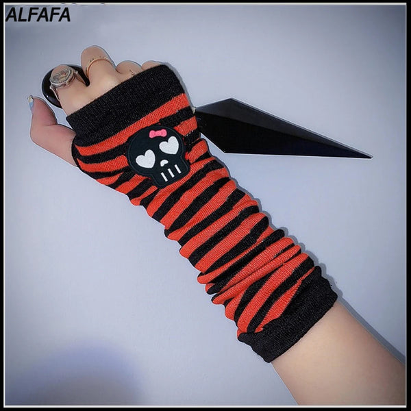 Eine Hand trägt einen schwarz-orange gestreiften Fingerless-Sleeve mit Totenkopf-Design.