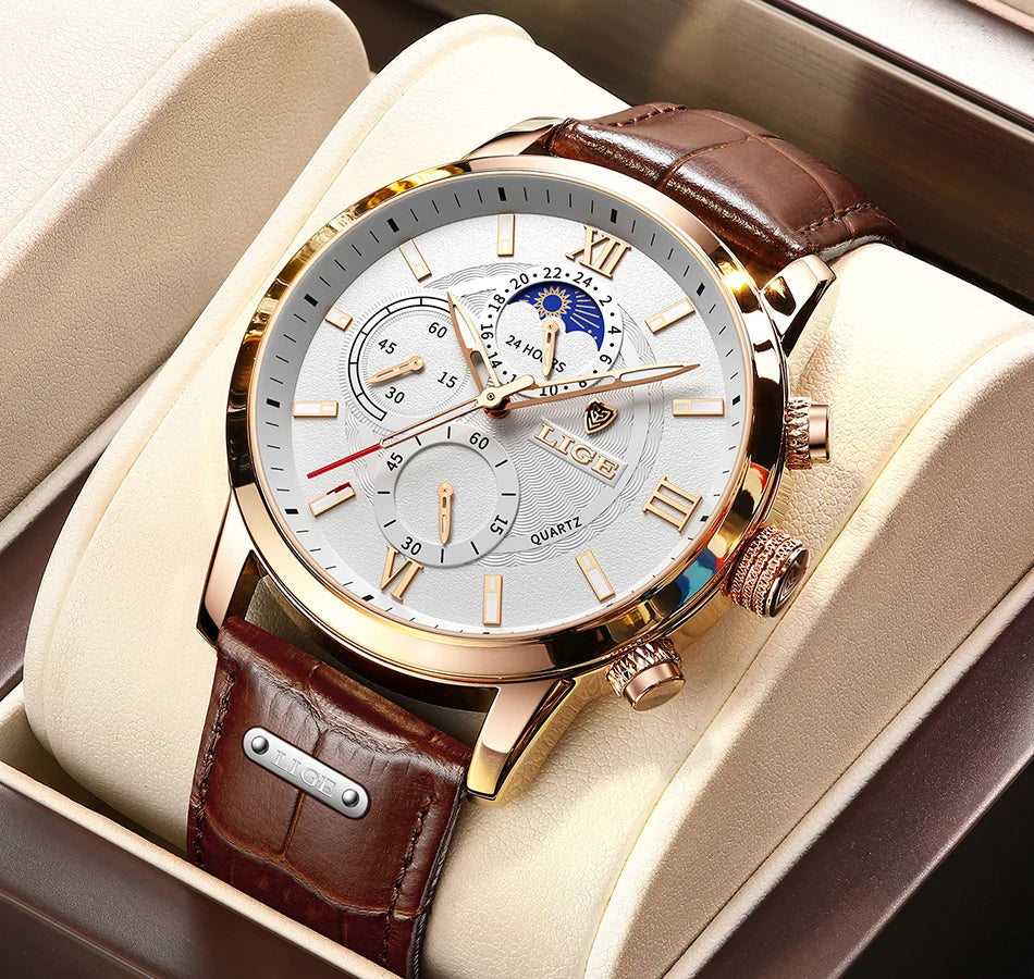 A luxury gold-toned men's quartz watch with a brown leather strap is displayed in a light beige presentation box.