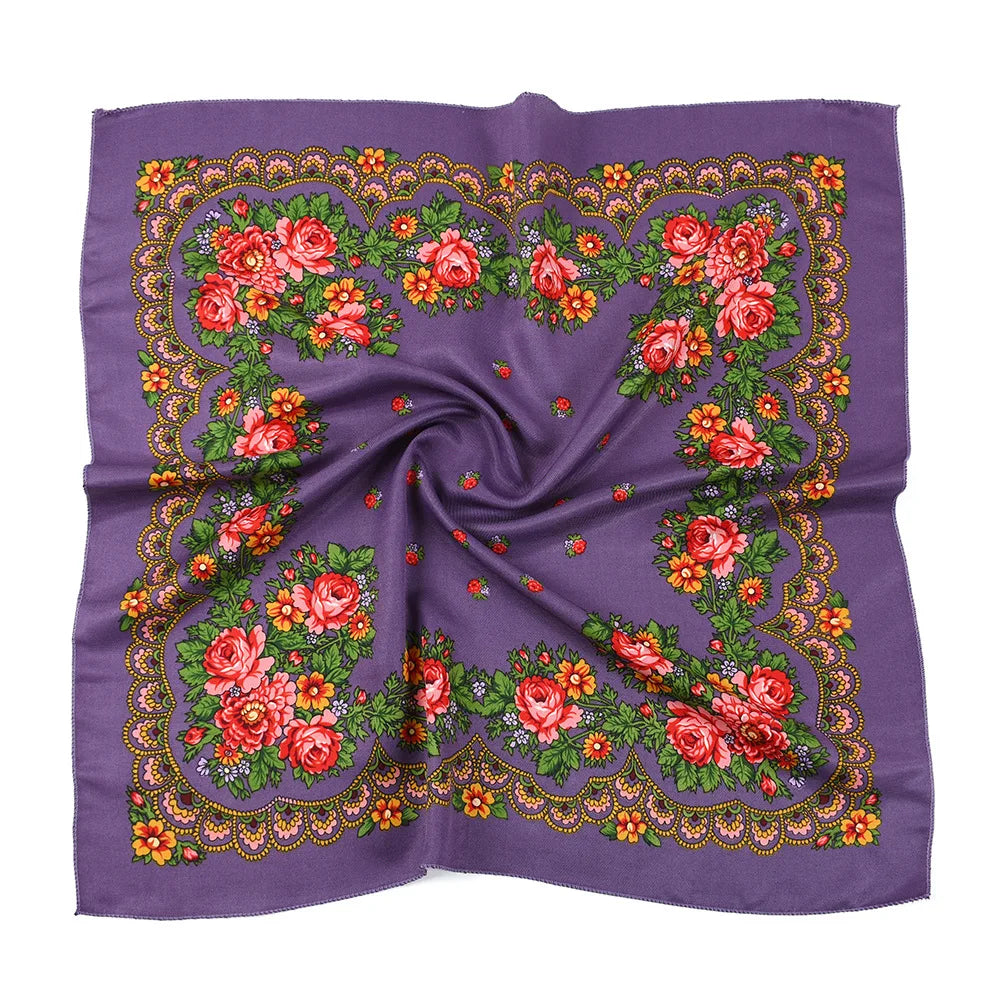 A purple square scarf featuring a detailed floral print with red and orange roses and green leaves.