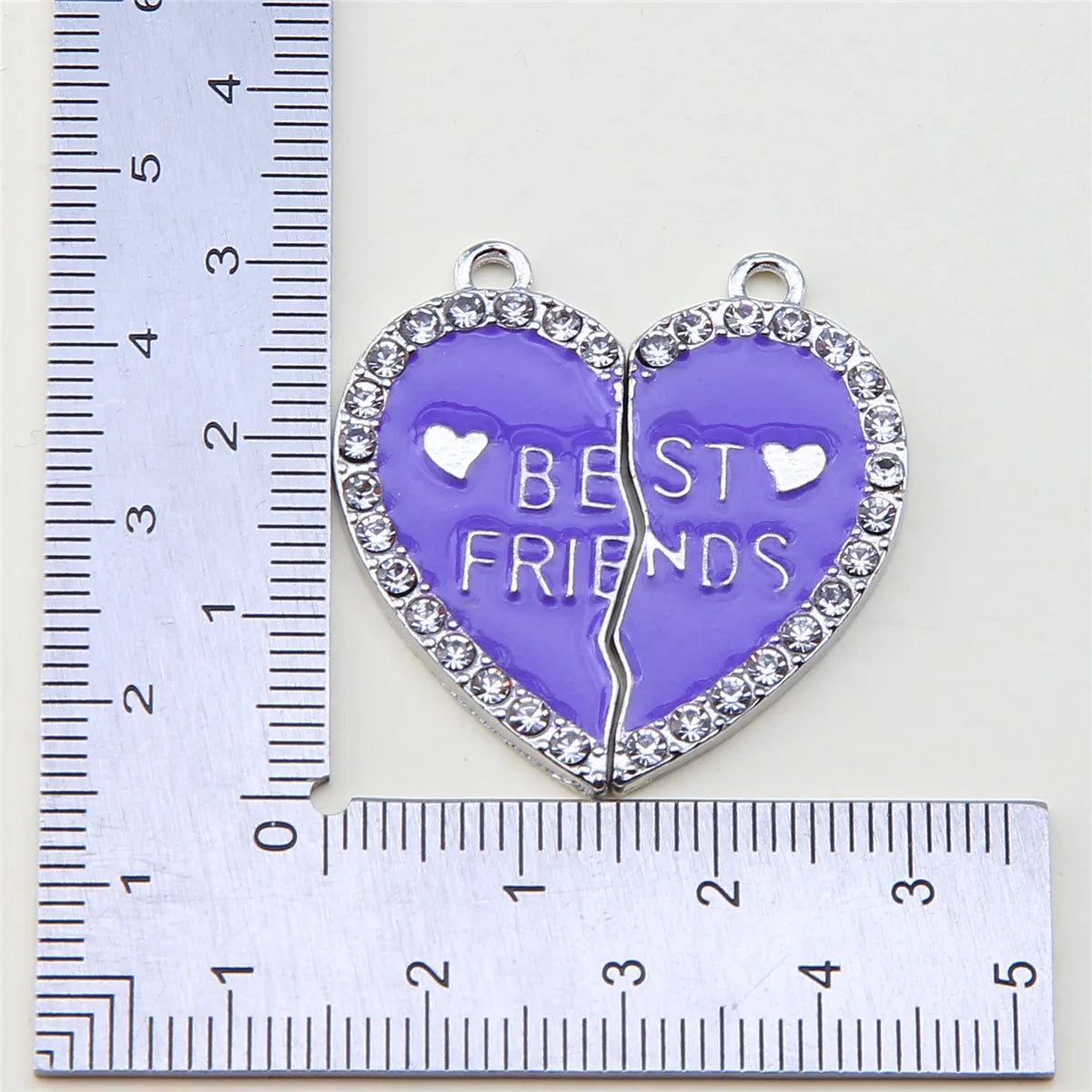 Colgante de corazón plateado grabado con MEJORES AMIGOS rodeado de pequeñas piedras claras