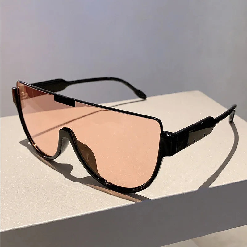 A pair of black vintage cat eye sunglasses with rose gold tinted lenses resting on a white surface.