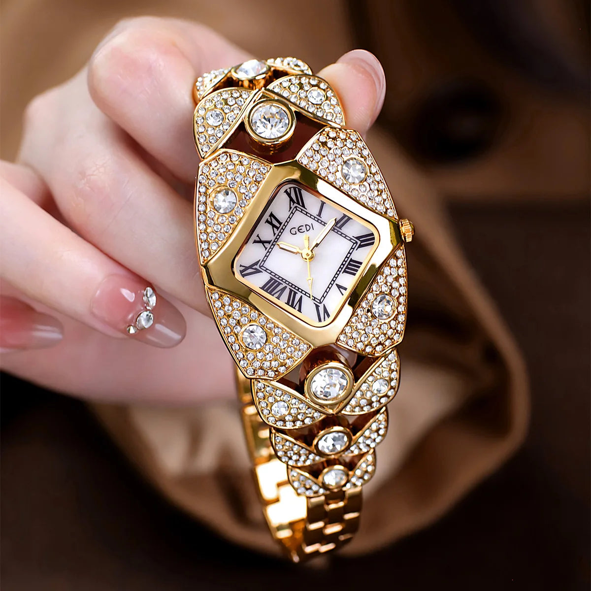 A hand holds a luxury diamond inlaid quartz wristwatch with a gold casing and diamond accents.