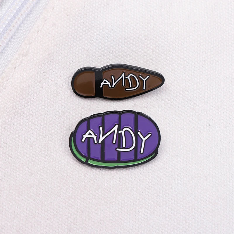 دبوسان تطبيقيان من الإنميل يحملان اسم ANDY، واحد بني وآخر بنفسجي.
