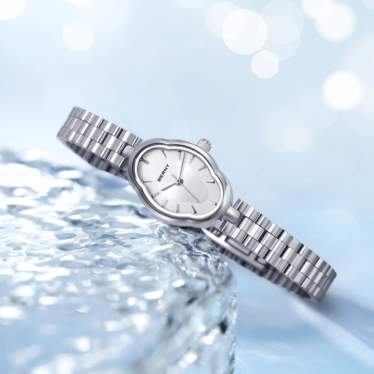 Une montre-bracelet en quartz en acier inoxydable argenté repose sur une surface claire texturée avec des lumières bokeh douc