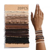 A hand holds a collection of 20 pairs of brown and black boho hair ties and headbands.