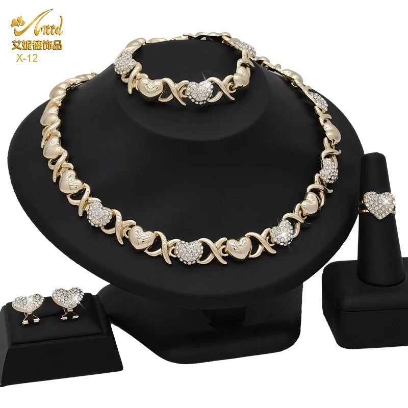 A gold heart crystal jewelry set featuring necklaces and earrings displayed on a black stand.