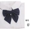 A navy blue butterfly ribbon tie set displayed on a white collared shirt.