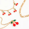 Gold chain anklet set featuring small red and green cherry bead charms