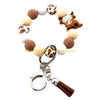 A silicone wristlet keychain featuring a decorative border of cow and horse-themed charms.