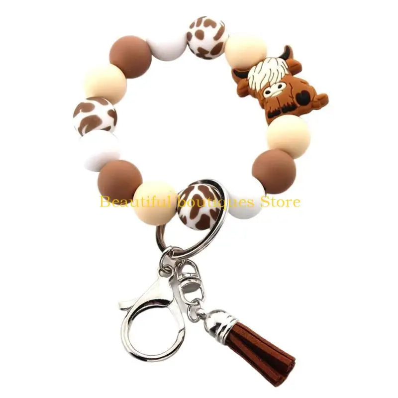 A silicone wristlet keychain featuring a decorative border of cow and horse-themed charms.