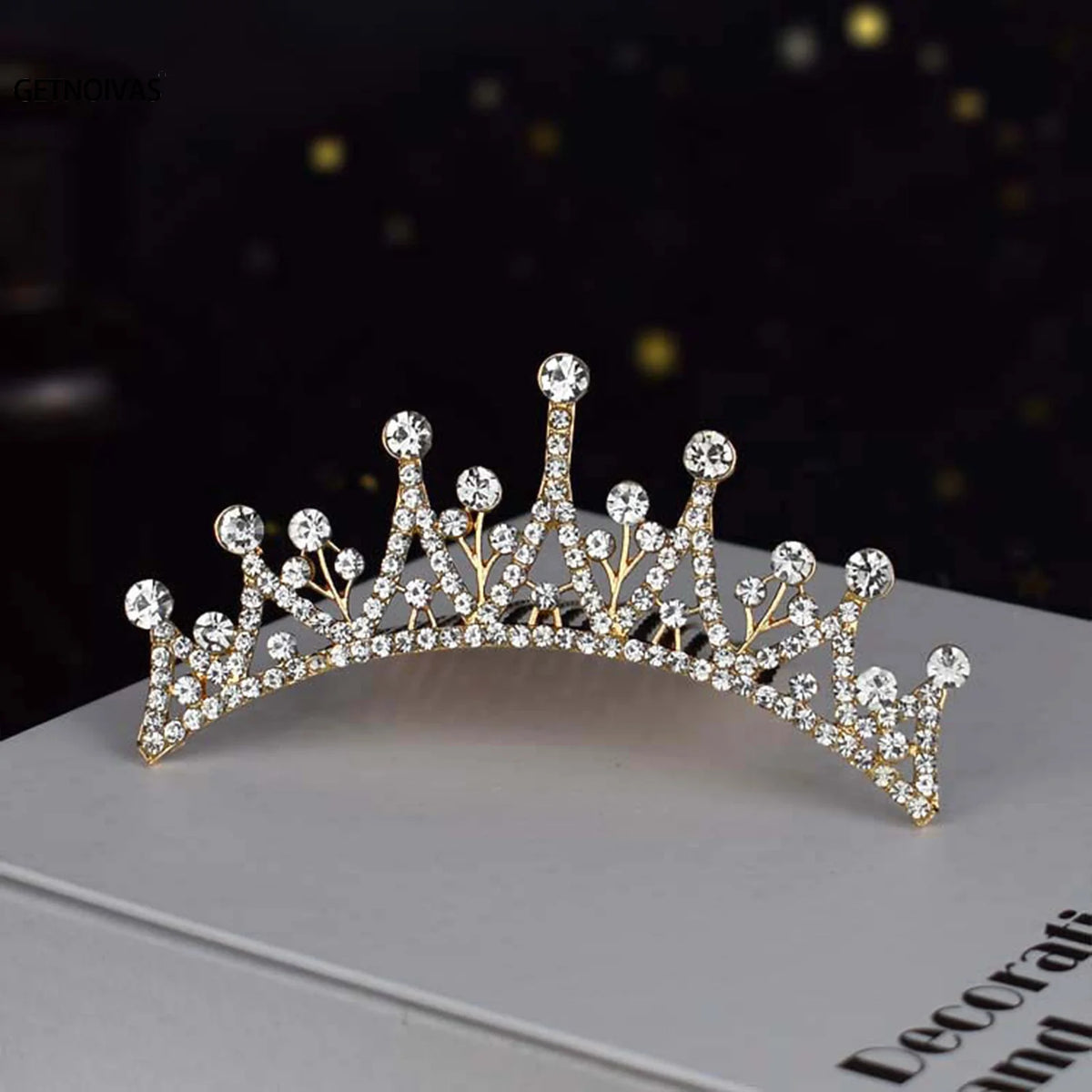 A sparkling crystal princess tiara hair comb for women displayed on a light gray box.