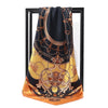 A black silk print shawl with gold embroidery draped over a dark frame.