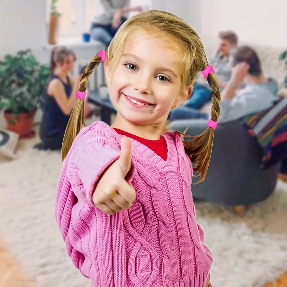 A smiling young girl with pink braided pigtails is holding up her finger in a playful pose.