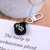 A black LED digital keychain watch with a flower design attached to a silver keyring on a white background.