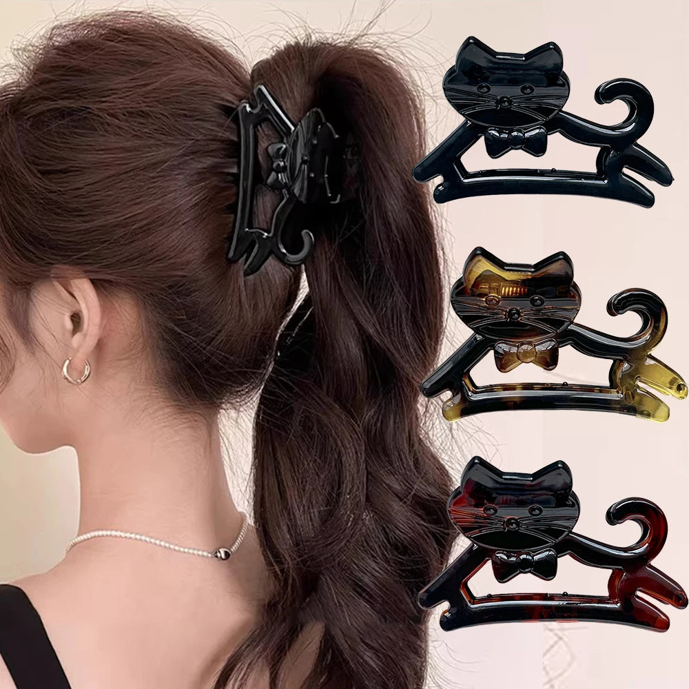 A set of three black and amber cat-shaped hair clips for hair decoration.