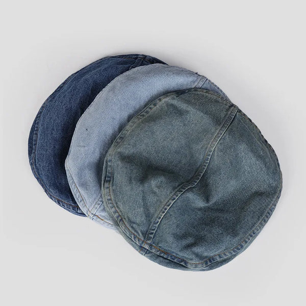 A stack of three retro washed cotton denim beret hats in shades of blue and gray.