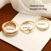 Gold alloy cuff bangle bracelet shown on a white surface with a sheer fabric background.