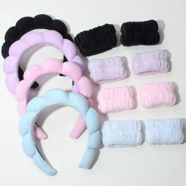 Un set de trois bandeaux pour la tête et les poignets de spa noirs, roses et bleu clair.
