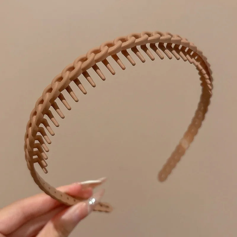 Gros plan d'un bandeau anti-dérapant pour cheveux beige clair et givré tenu par une main.