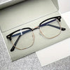 A pair of retro half gold frame anti blue light eyewear resting in a light gray box.