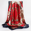 A vibrant red silk print shawl featuring intricate gold and beige patterns draped elegantly.