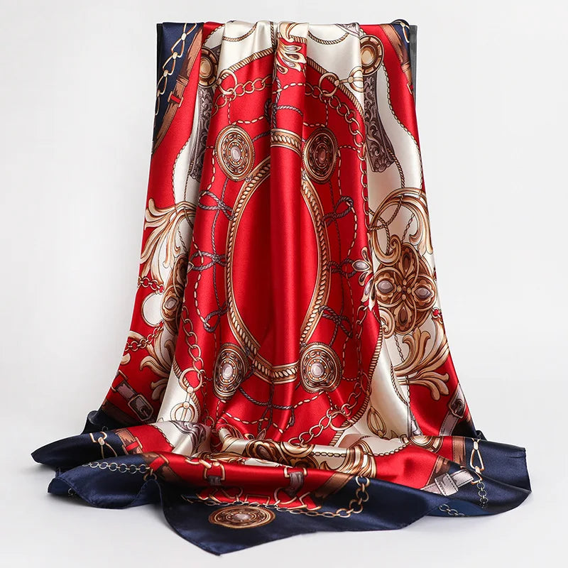 A vibrant red silk print shawl featuring intricate gold and beige patterns draped elegantly.