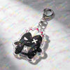 A clear acrylic keychain featuring a black cat face with white accents and pink spiky ears.