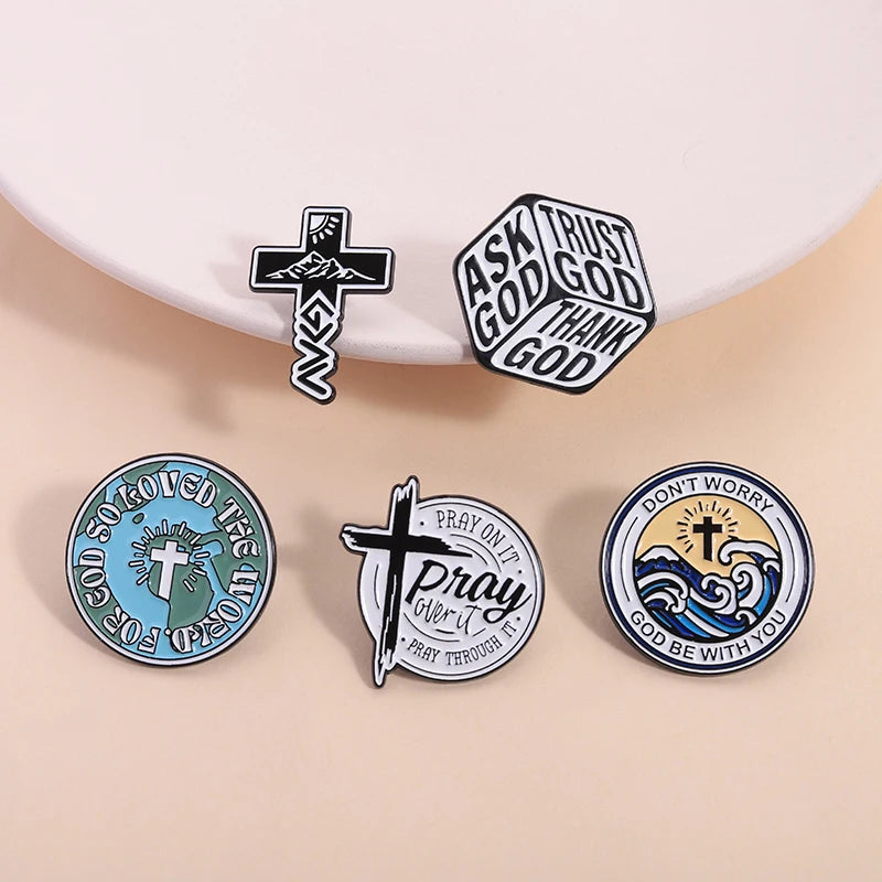 Collection de pins en émail avec des symboles chrétiens comme des croix et des phrases telles que 'Ask God', 'Trust God', 'Th