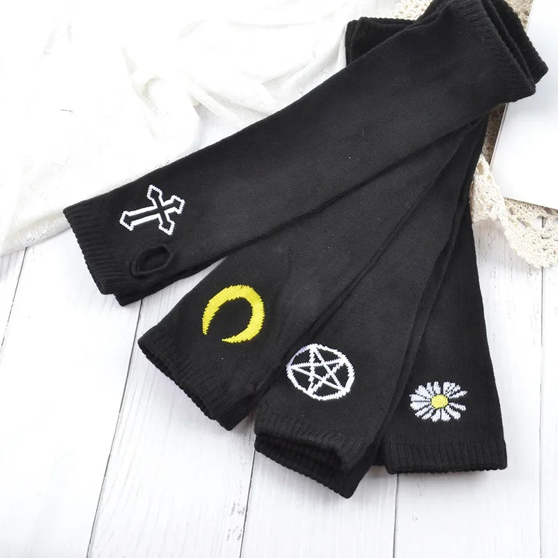 Black knitted fingerless gloves featuring white and yellow symbols on the palm area