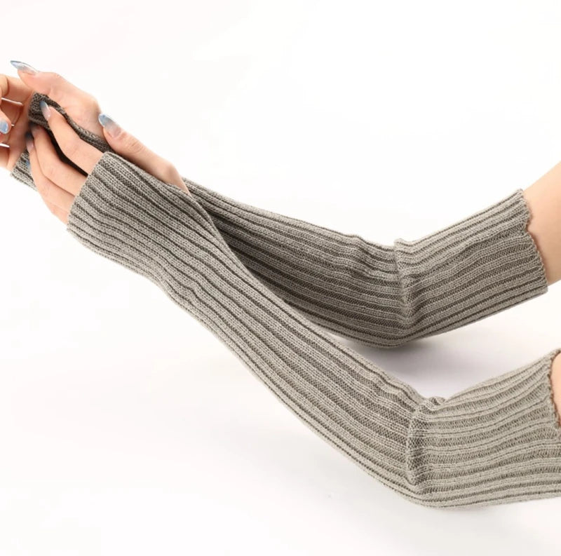 A hand wearing knitted fingerless gloves in a gray color against a white background.